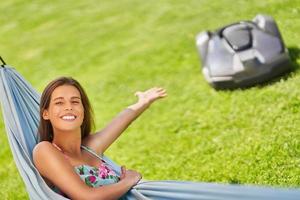 Pretty Woman relajándose en una hamaca con automower en segundo plano. foto