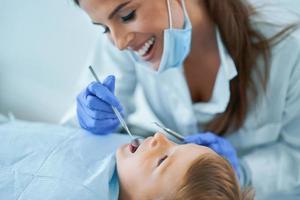 niño pequeño y mujer dentista en la oficina de dentistas