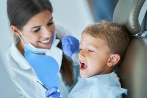 niño pequeño y mujer dentista en la oficina de dentistas foto