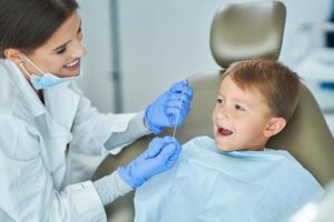 niño pequeño y mujer dentista en la oficina de dentistas foto