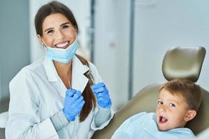 niño pequeño y mujer dentista en la oficina de dentistas foto