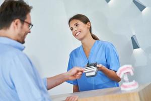 Patient paying for dental visit in clinic photo