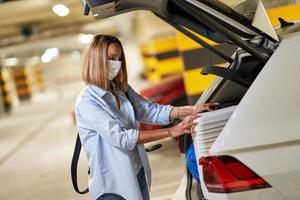 Adult woman tourist wearing mask in underground airport parking lot photo