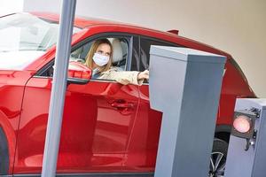 Woman getting ticket from parking meter in underground parking photo