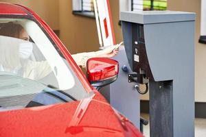 Woman getting ticket from parking meter in underground parking photo