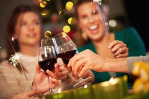 grupo de amigos celebrando la navidad y bebiendo vino foto