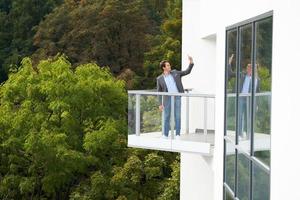 Businesswoman standing on balcony against nature photo