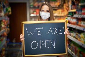 Shop assistant holding announcement board photo