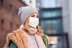 mujer con mascarilla debido a la contaminación del aire o la epidemia de virus en la ciudad foto