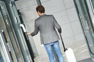 Businessman entering building using hand sanitizer due to covid-19 photo