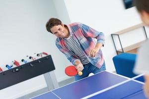 grupo de estudiantes jugando tenis de mesa en el campus foto