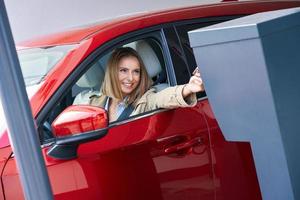 Woman getting ticket from parking meter in underground parking photo