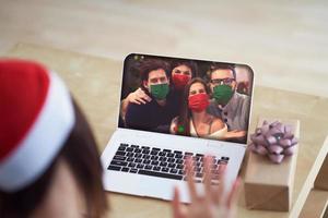 Adult woman celebrating Christmas at home and making video call with friends photo