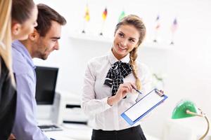 Hotel receptionist talking with guests photo