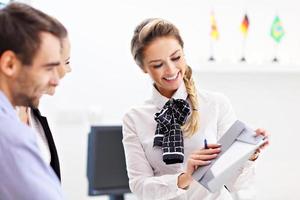 Hotel receptionist talking with guests photo