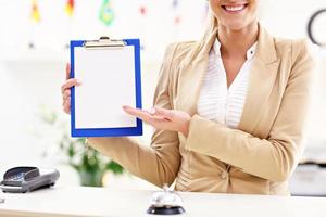 Happy receptionist working in hotel photo