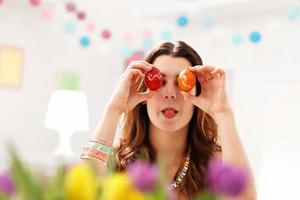 mujer atractiva pintando huevos de pascua en casa foto