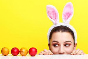 Happy young woman wearing bunny ears and having Easter Eggs photo