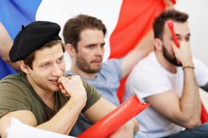 Happy male friends cheering and watching sports on tv photo