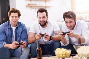 Friends having fun on the couch with video games photo