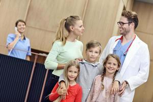 Mother and children together in hospital with doctor photo