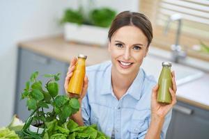 Healthy adult woman with green food in the kitchen photo