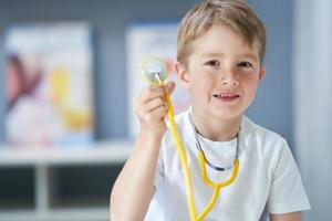 A little doctor with stethoscope smiling in doctor's office photo