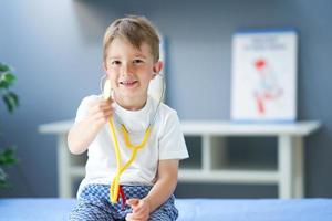 A little doctor with stethoscope smiling in doctor's office photo