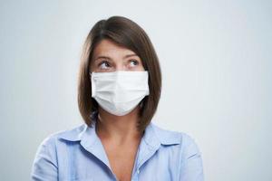 Attractive woman wearing protective mask isolated over white background photo