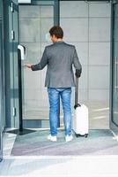 Businessman entering building using hand sanitizer due to covid-19 photo