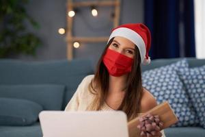 Adult woman celebrating Christmas at home and making video call with friends photo