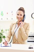 Happy receptionist working in hotel photo