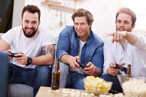 Friends having fun on the couch with video games photo