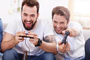 Friends having fun on the couch with video games photo