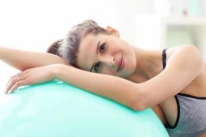 mujer haciendo ejercicios de fitness en casa descansando sobre la pelota foto