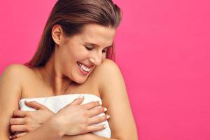 Beautiful woman posing against pink background photo