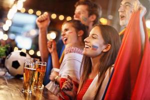 Group of friends watching soccer in pub photo