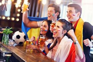 Group of friends watching soccer in pub photo