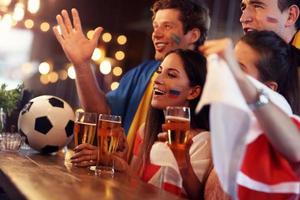 grupo de amigos viendo fútbol en el pub foto