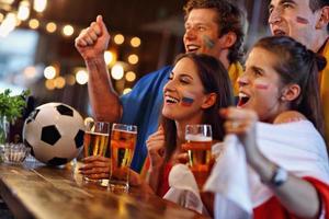 grupo de amigos viendo fútbol en el pub foto