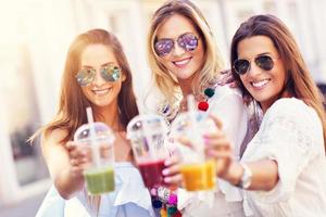 Happy girl friends hanging out in the city in summer photo