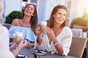 Happy girl friends in cafe during summer time photo