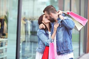 retrato de pareja feliz con bolsas de compras después de ir de compras en la ciudad foto