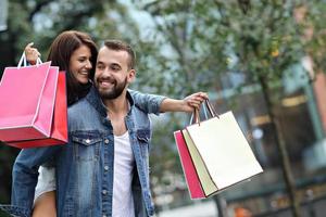 Portrait of happy couple with shopping bags after shopping in city photo