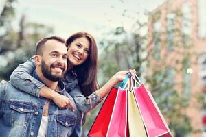 retrato de pareja feliz con bolsas de compras después de ir de compras en la ciudad foto