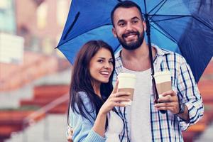 pareja feliz bajo el paraguas en la ciudad foto