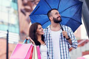 Portrait of happy couple with shopping bags after shopping in city photo