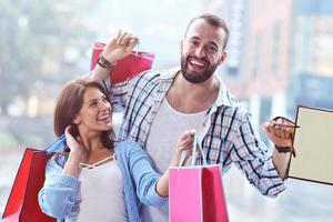 Portrait of happy couple with shopping bags after shopping in city photo