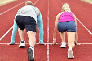 Man and woman racing on outdoor track photo