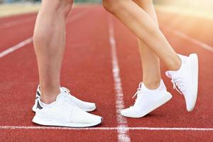 Man and woman racing on outdoor track photo